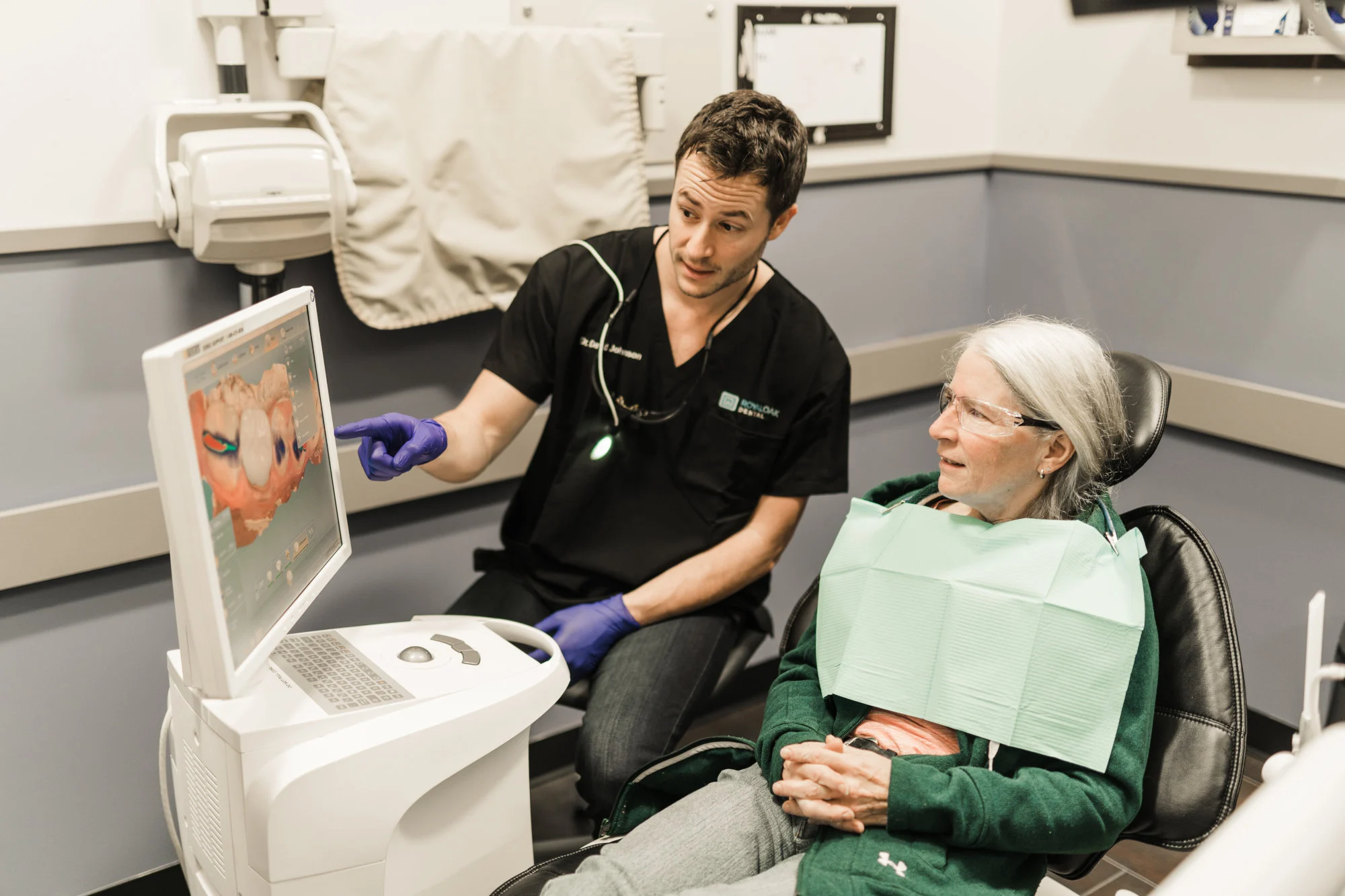 A patient has a Dental Crown consultation with a dentist. The patient is shown a 3D dental impression scan.