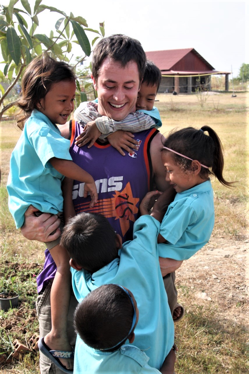 Dr. Johnson plays with kids while providing dental care to the people of Cambodia in a Humanitarian Outreach project.